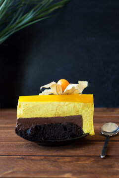 Delicious piece of chocolate cake with fesalis on black plate on table 