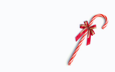 Christmas candy cane with red ribbon bow on white background with copy space. Christmas celebration  decoration elements.