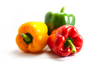 Three colors of bell peppers, green, red, yellow on a white background.