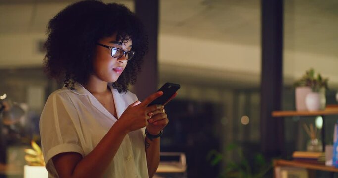 Corporate female professional searching internet while doing overtime at work. Lady browsing the web for ideas. Young business woman typing a text online on a phone while working late in an office.