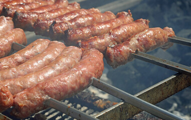 sausage skewers they are making over the burning embers in a restaurant specializing in bbq