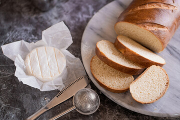Still life on the kitchen table with baguette sliced ​​bread with brie cheese.
