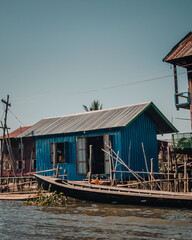 Burmese style wooden houses on stilts on Inle Lake in Myanmar on a sunny day.