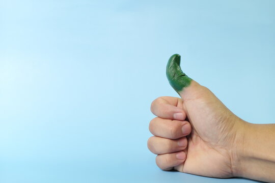 Green thumb and environmentalist concept. Human thumb up painted with color green.