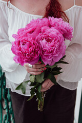 Woman holding a beautiful bouquet of pink peonies for wedding celebration