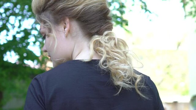 Slow Motion Natural unbrushed hair of a young woman in a messy up do hairstyle.