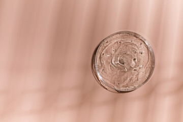 Hyaluronic acid in a petri dish on a pink background with shadow drawing. The texture of a cosmetic product.