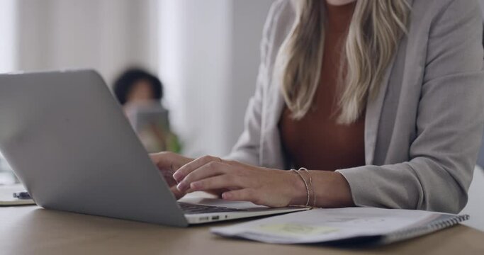 Closeup of a businesswoman browsing on a laptop while working in an office. Hands of an entrepreneur typing emails and compiling online reports while doing research and planning in a startup company