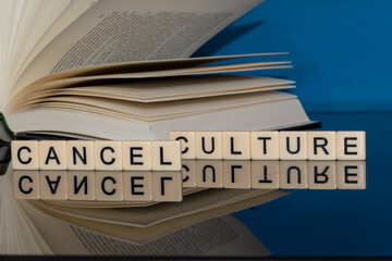 Symbolbild Cancel Culture: Buchstabenwürfel zeigen die Worte Cancel Culture vor einem Buch