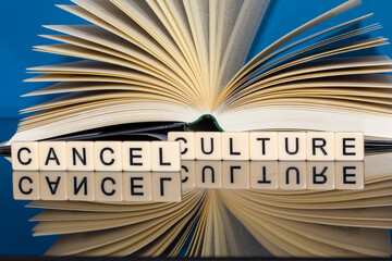 Symbolbild Cancel Culture: Buchstabenwürfel zeigen die Worte Cancel Culture vor einem Buch