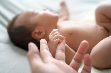 Close of hand holding new born baby's finger