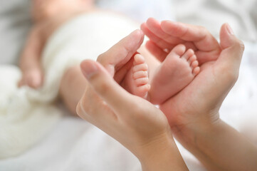 Fototapeta na wymiar Close of hand holding new born baby's feet
