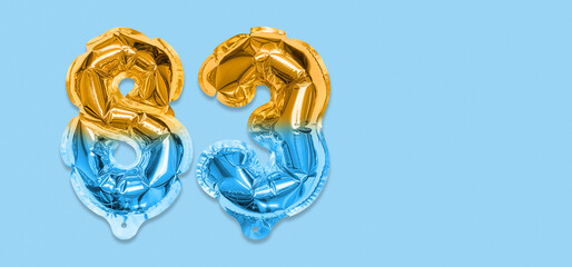 Rainbow foil balloon number, digit eighty three on a blue background. Birthday greeting card with...