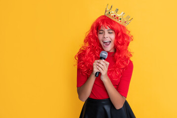 kid smile in crown with microphone on yellow background