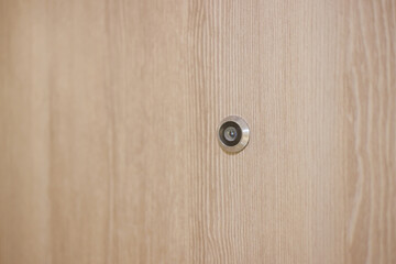 door lens peephole on wooden background and texture. eyehole on front door hotel.