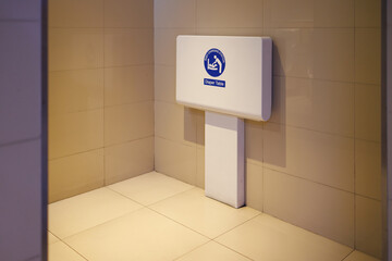 baby changing station in public toilet room. foldable diaper table on wall.