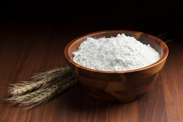 テーブルの上に木製のボウルにはいった小麦粉