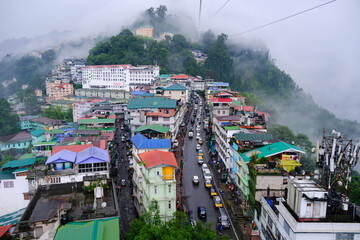 Gangtok, Sikkim, Tourists enjoy a ropeway cable car ride over Gangtok city. Amazing aerial cityscape of Sikkim. covered in mist or fog. North east India tourism, Amazing aerial cityscape of Sikkim. - obrazy, fototapety, plakaty
