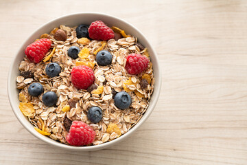 Eine Schale Müsli mit frischen Heidelbeeren und Himbeeren