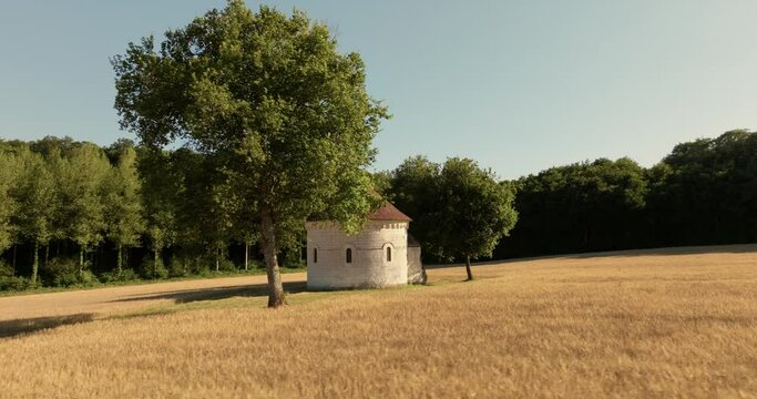 Aerial view of the chapel of the Liget next to wheat fields during sunset in France.