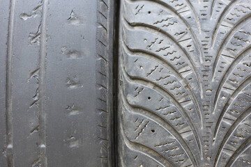 Old summer tire next to winter old tire as example of worn out summer tires and winter tires