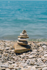 Fototapeta na wymiar Balanced stones on a pebble beach. Sea stones arranged in a balance pyramid on the beach.
