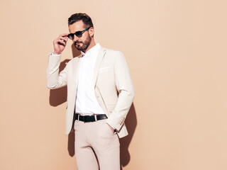 Portrait of handsome confident stylish hipster lambersexual model. Sexy modern man dressed in white...