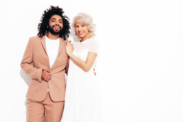 Smiling beautiful woman and her handsome boyfriend. Sexy cheerful multiracial family having tender moments on white background in studio. Multiethnic models hugging. Embracing each other.Love concept