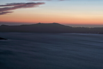 Panoramic view of the caldera, the volcano of Santorini and a beautiful colourful sky
