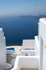 A beautiful  terrace with sunbeds, swimming pool and a breathtaking view over the Aegean Sea in Santorini Greece