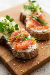 Sandwiches with salted salmon,  avocado and microgreens.