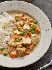 Chicken stew with vegetables and mushroom cream sauce. Tender chicken fillet in a creamy mushroom sauce with rice and green peas.