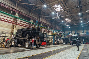 Factory hangar with combine harvesters assembled. Industrial production of agricultural machinery.