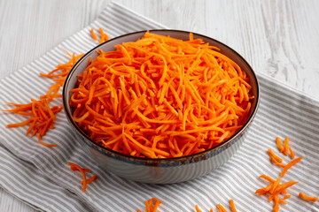 Raw Orange Carrot Shreds in a Bowl, side view.
