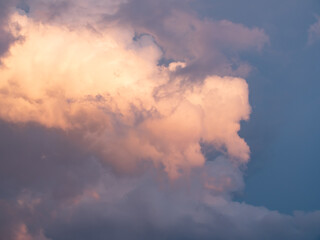 Cumulus clouds shines orange at the horizon during the thunderstorm. Weather, clouds, temperature...
