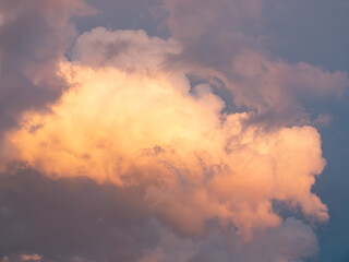 Cumulus clouds shines orange and pink at the horizon during the thunderstorm. Weather, clouds,...