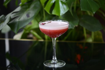 alcoholic red cocktail decorated with a flower in a glass
