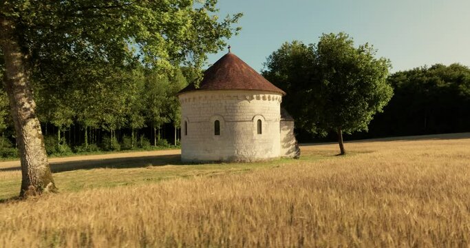 Aerial view of the chapel of the Liget next to wheat fields during sunset in France.