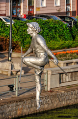 Passing through the river - a sculpture suspended on a rope by the Brda River. Bydgoszcz, Kuyavian-Pomeranian Voivodeship, Poland. - obrazy, fototapety, plakaty