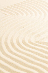 Fototapeta na wymiar closeup of sand pattern of a beach in the summer. Zen relaxation waves on the sand.