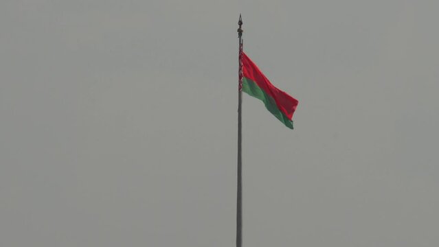 Minsk, Belarus. June 27, 2022. The national flag of the Republic of Belarus flutters against a gray sky.