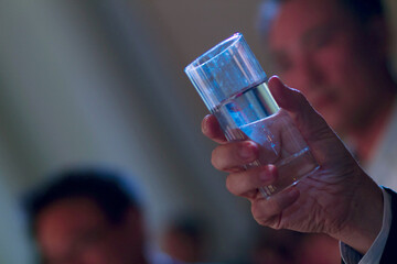 A glass of water with water in a glass, held by the President.