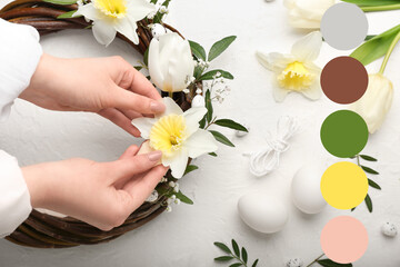 Woman making Easter wreath with beautiful flowers on light background. Different color patterns