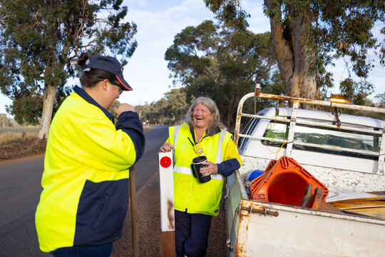 outdoor workers wearing hi-vis workwear having a break at side of road