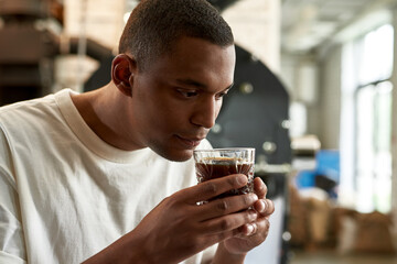 Barista sniffing aromatic natural coffee in glass - obrazy, fototapety, plakaty