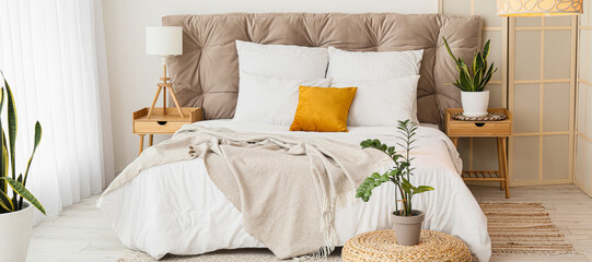 Interior of modern bedroom with stylish folding screen and bedside tables