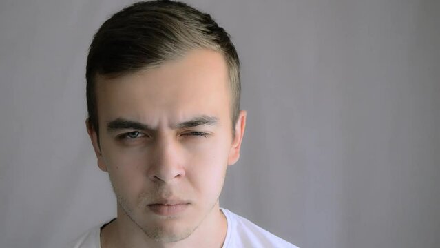 Emotional angry man portrait. Portrait of a young angry guy. Facial emotions, expressions, anger, disgust, anger, negativity