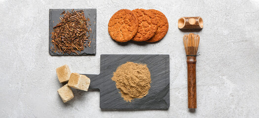 Green powder with hojicha green tea, cookies, marshmallows and chasen on grunge background