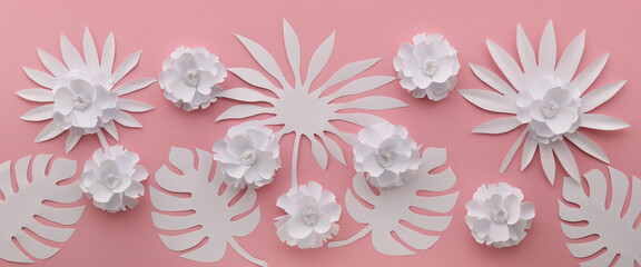 Composition with beautiful paper flowers and tropical leaves on pink background