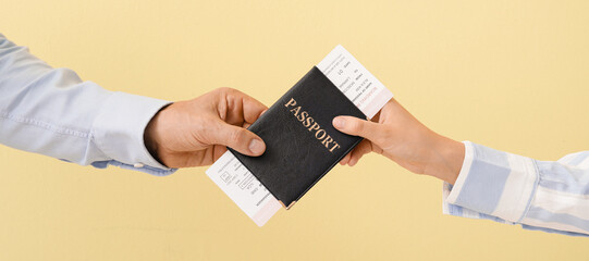 Travel agent giving client passport and tickets on yellow background